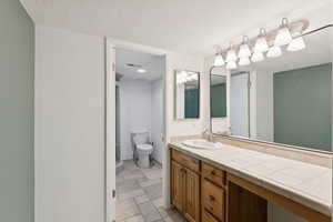Bathroom featuring vanity and a textured ceiling
