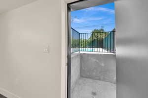 Balcony featuring view of pool area