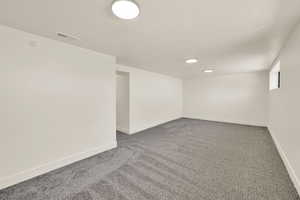 Basement featuring carpet floors, a textured ceiling, and recessed lighting