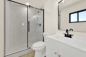 Bathroom featuring vanity, a shower stall, and wood finished floors