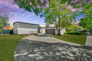 View of front of home featuring concrete driveway, brick siding, and an attached garage