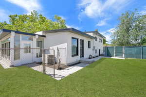 Rear view of property featuring a gate and a sunroom