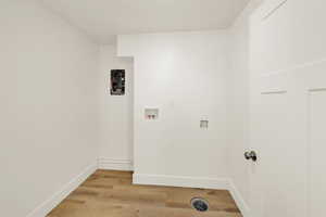 Laundry room with hookup for a washing machine and light wood finished floors