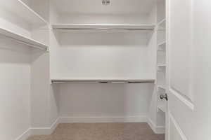 Walk in closet featuring light carpet
