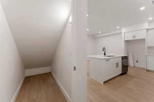 Stairs with wood finished floors and recessed lighting