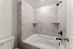 Bathroom featuring toilet and shower / washtub combination