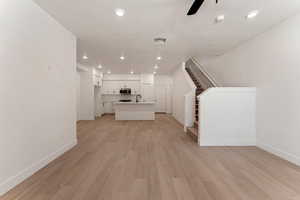 Unfurnished living room featuring recessed lighting, stairway, light wood finished floors, a ceiling fan, and a textured ceiling