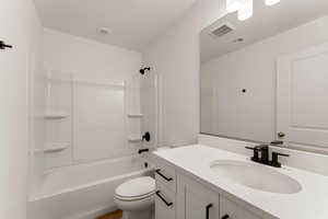 Bathroom featuring vanity, tub / shower combination, and a textured ceiling