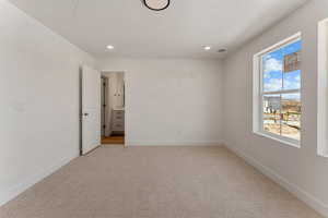 Unfurnished bedroom featuring light colored carpet, recessed lighting, and a textured ceiling