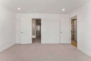 Unfurnished bedroom with light colored carpet, recessed lighting, and a textured ceiling