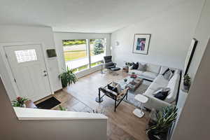 Living room with a textured ceiling and wood finished floors