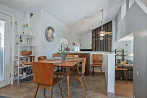 Dining room with a ceiling fan, a textured ceiling, and high vaulted ceiling