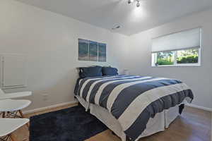 Bedroom with baseboards and wood finished floors
