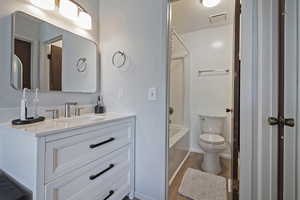 Bathroom featuring vanity, wood finished floors, and shower / tub combination