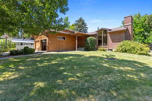 View of front of property with a chimney and a front lawn