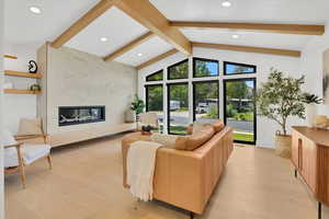 Living area with engineered hardwood flooring, fireplace and large windows