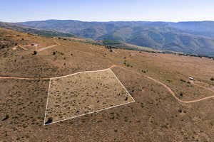 Overview of rural landscape with property parcel outlined and mountains
