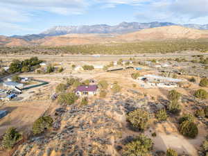 Aerial view of property and surrounding area featuring rural landscape and a mountain backdrop