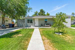 Single story home with a front yard, driveway, RV pad, and a garage