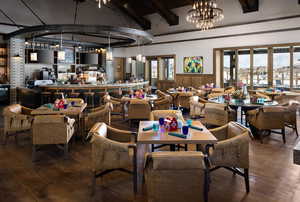 Dining room with wood finished floors, a chandelier, and a wainscoted wall