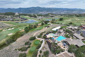 View of property location with a golf club and a water and mountain view