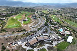 Aerial overview of property's location featuring a golf course and a mountainous background
