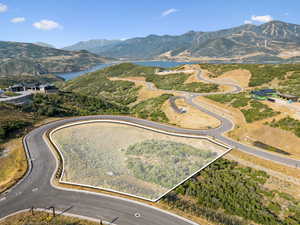 Aerial view of property and surrounding area featuring property parcel outlined and a water and mountain view