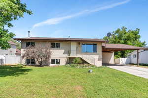 View of front of house featuring concrete driveway and an attached carport
