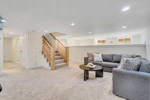 Carpeted living area featuring recessed lighting and stairway