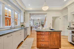 Kitchen featuring crown molding, backsplash, stone countertops, light wood-type flooring, and recessed lighting