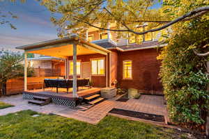 Rear view of house with a patio area, a deck, outdoor lounge area, a shingled roof, and brick siding