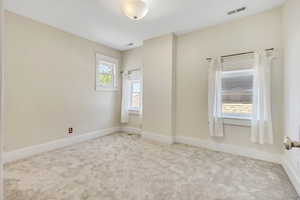 Carpeted empty room featuring baseboards