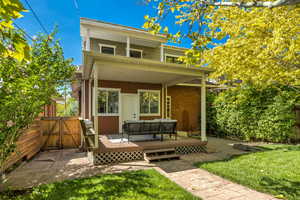 Rear view of house with an outdoor hangout area, a deck, a gate, and brick siding