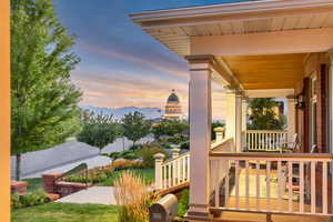 Balcony at dusk featuring covered porch and a mountain view