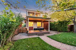Back of property featuring a fenced backyard, a deck, an outdoor hangout area, and a gate