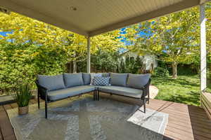 Deck with an outdoor living space, an outbuilding, and a lawn