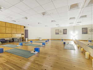 Exercise room featuring wood-type flooring and a paneled ceiling