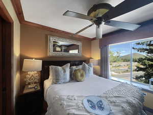 Bedroom with a mountain view, a ceiling fan, and ornamental molding