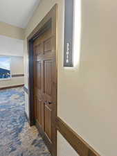 Hall featuring dark carpet
