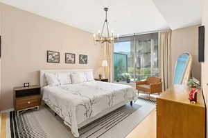 Bedroom with a chandelier and light wood-style floors