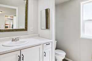 Bathroom with a textured ceiling and vanity
