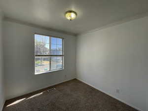 Carpeted 2nd bedroom with crown molding and baseboards