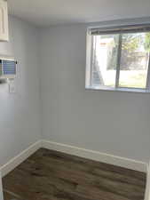 :aundry room featuring baseboards and dark wood-type flooring