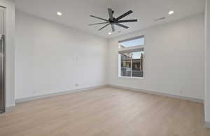 Unfurnished room featuring light wood-type flooring, recessed lighting, a ceiling fan, and a fireplace