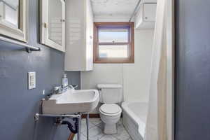 Bathroom featuring tile patterned floors and shower / tub combo with curtain