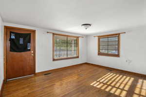 Entrance foyer with hardwood / wood-style floors and baseboards