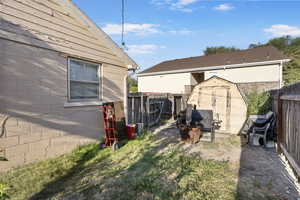 Fenced backyard featuring a storage unit