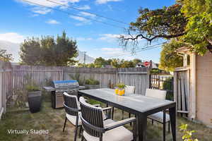 Fenced backyard featuring outdoor dining area and area for grilling