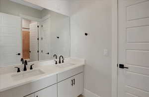 Full bath with double vanity and a shower