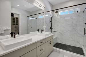 Bathroom featuring a stall shower and double vanity